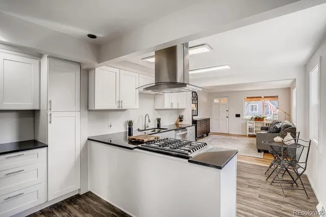 a kitchen with stainless steel appliances granite countertop a stove and white cabinets