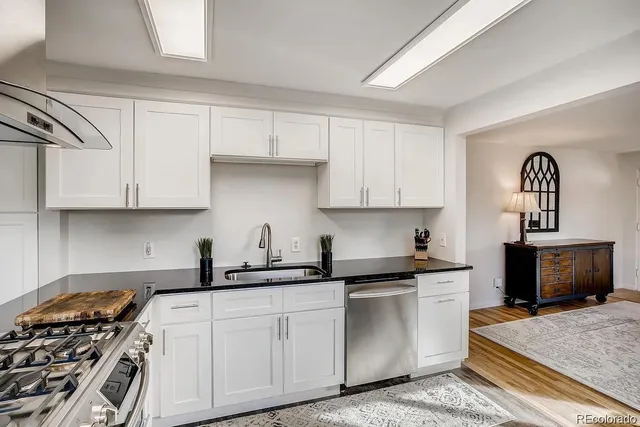a kitchen with white cabinets and appliances