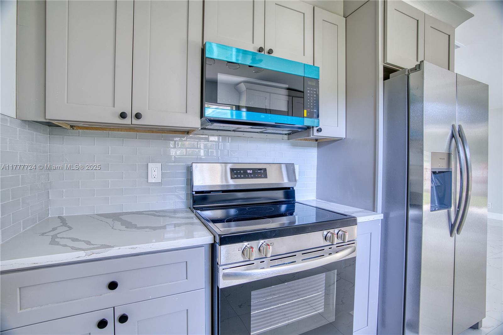 697 Pawnee Street Jupiter, FL 33458 - Photo 13 of 46 a kitchen with stainless steel appliances granite countertop white cabinets and a granite counter tops