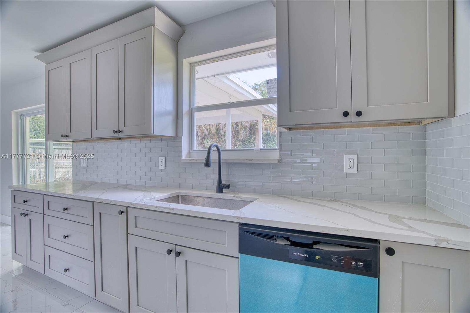 697 Pawnee Street Jupiter, FL 33458 - Photo 14 of 46 a kitchen with white cabinets and a window