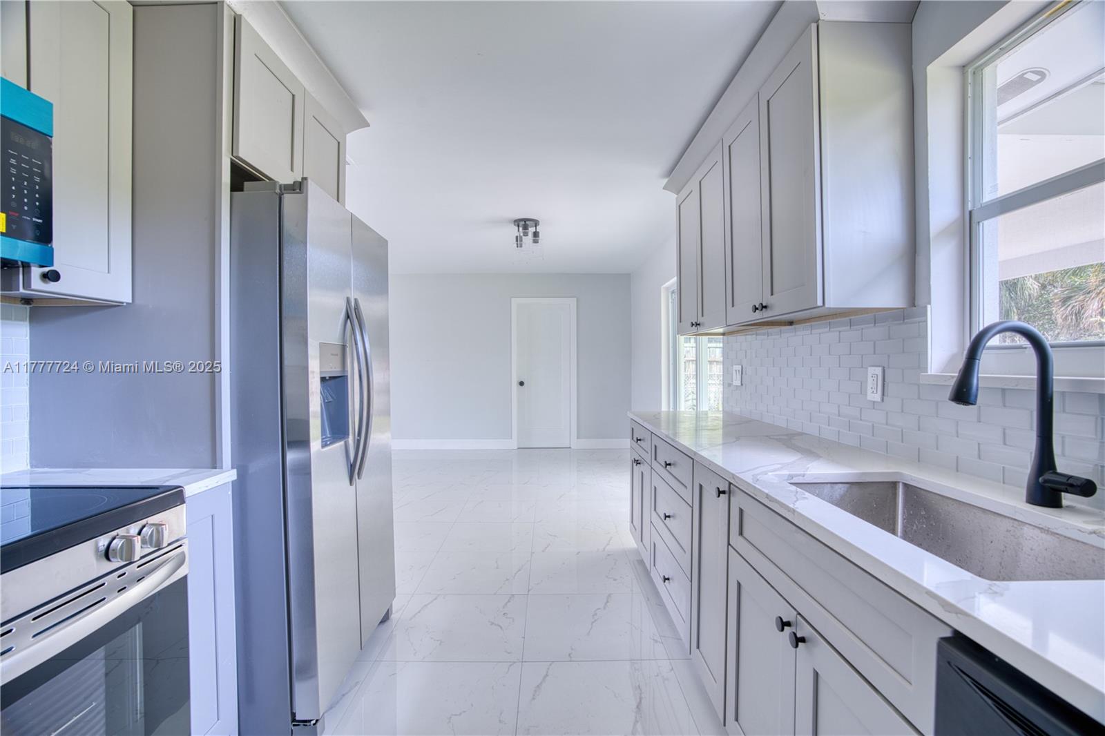 697 Pawnee Street Jupiter, FL 33458 - Photo 15 of 46 a kitchen with a sink stove and refrigerator