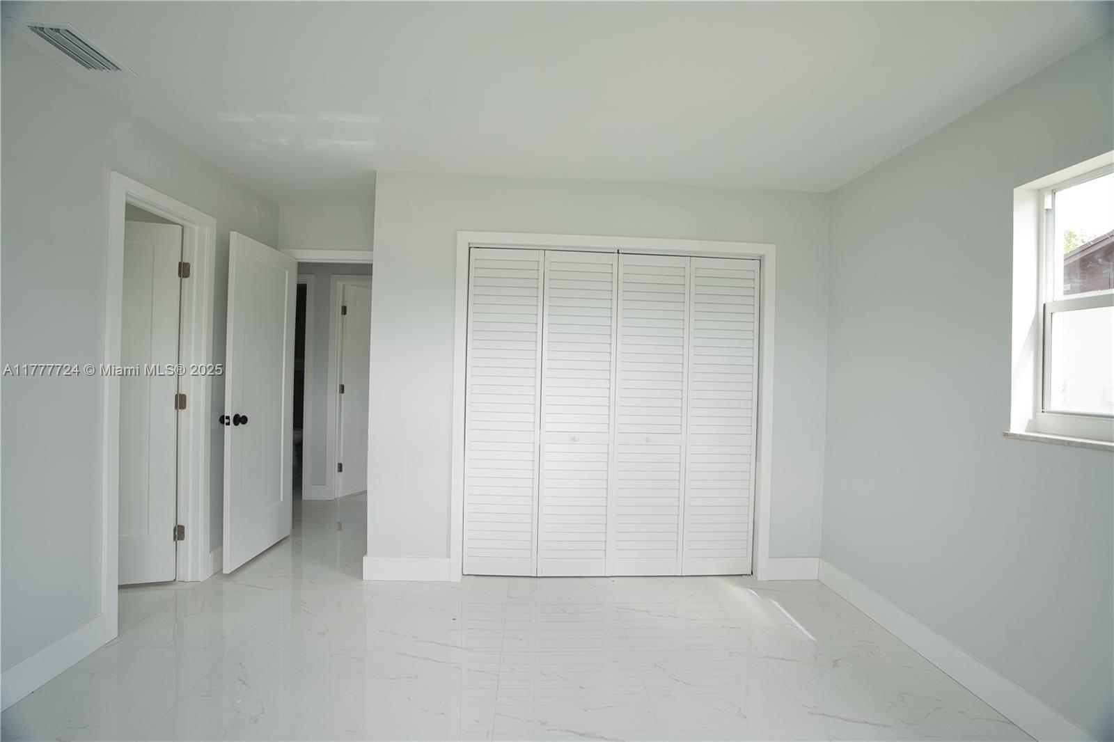 697 Pawnee Street Jupiter, FL 33458 - Photo 17 of 46 an empty room with windows and closet area