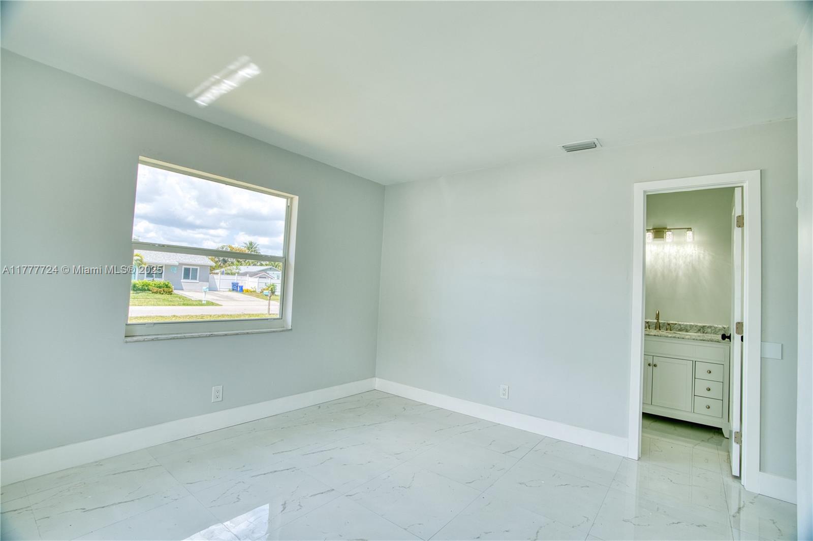 697 Pawnee Street Jupiter, FL 33458 - Photo 19 of 46 an empty room with windows and a bathroom