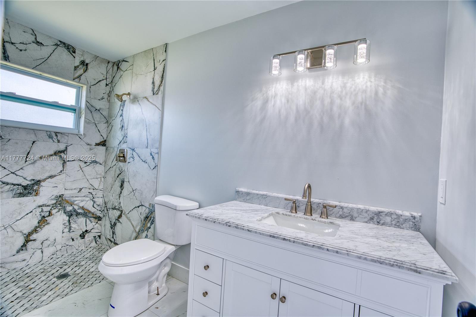 697 Pawnee Street Jupiter, FL 33458 - Photo 20 of 46 a bathroom with a granite countertop sink toilet and shower