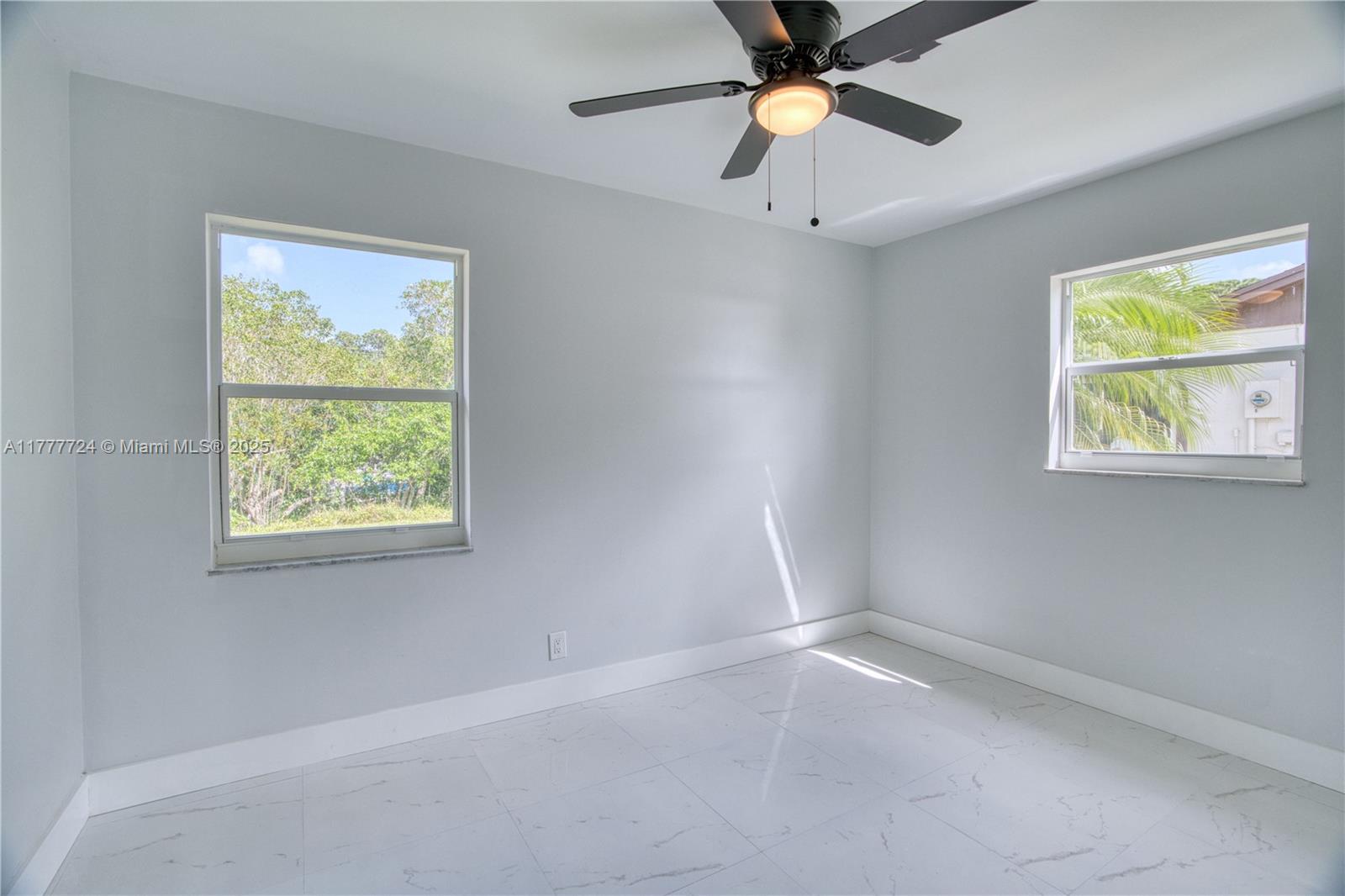 697 Pawnee Street Jupiter, FL 33458 - Photo 22 of 46 an empty room with windows and fan