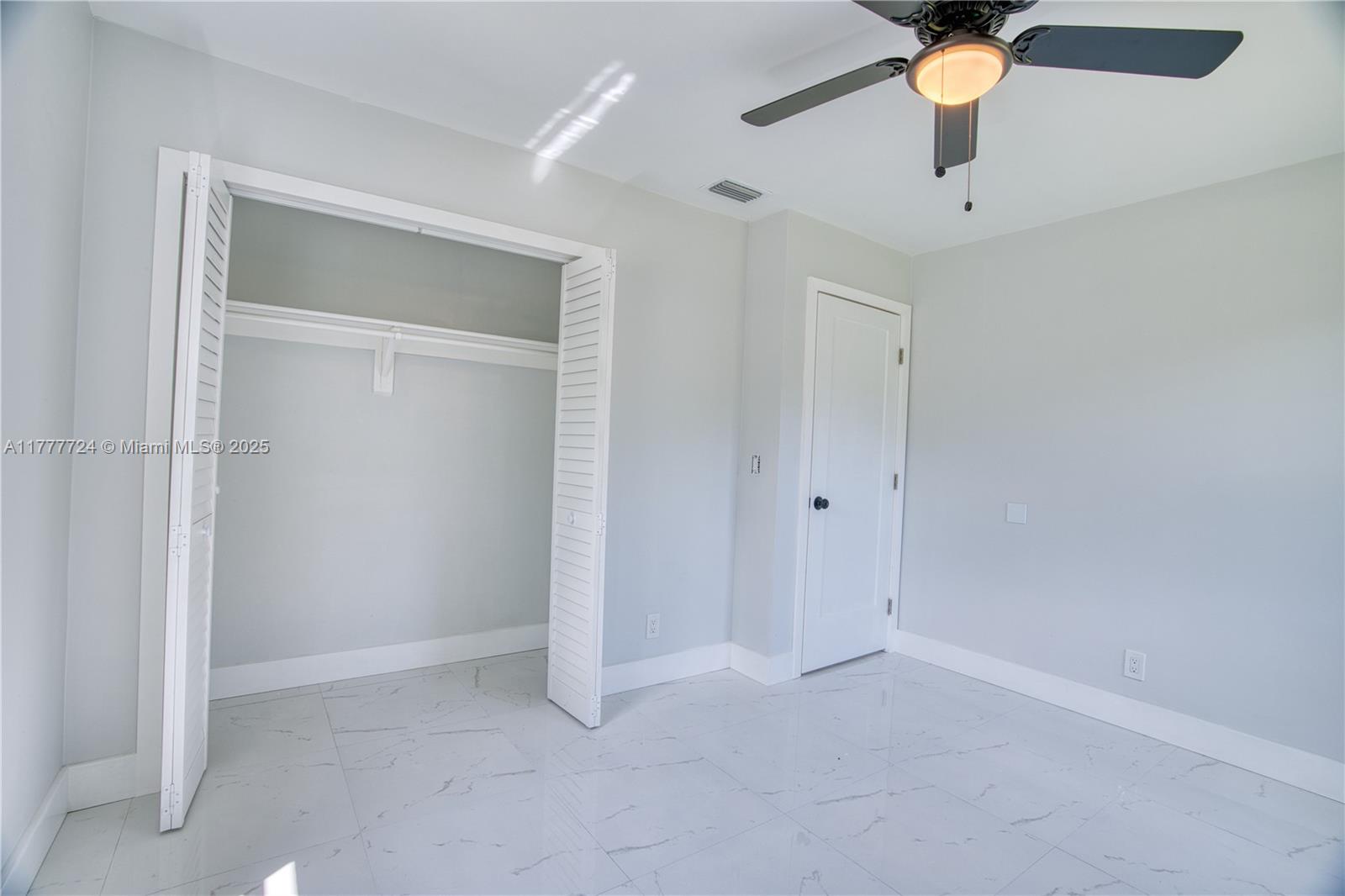 697 Pawnee Street Jupiter, FL 33458 - Photo 23 of 46 an empty room with a ceiling fan and carpet