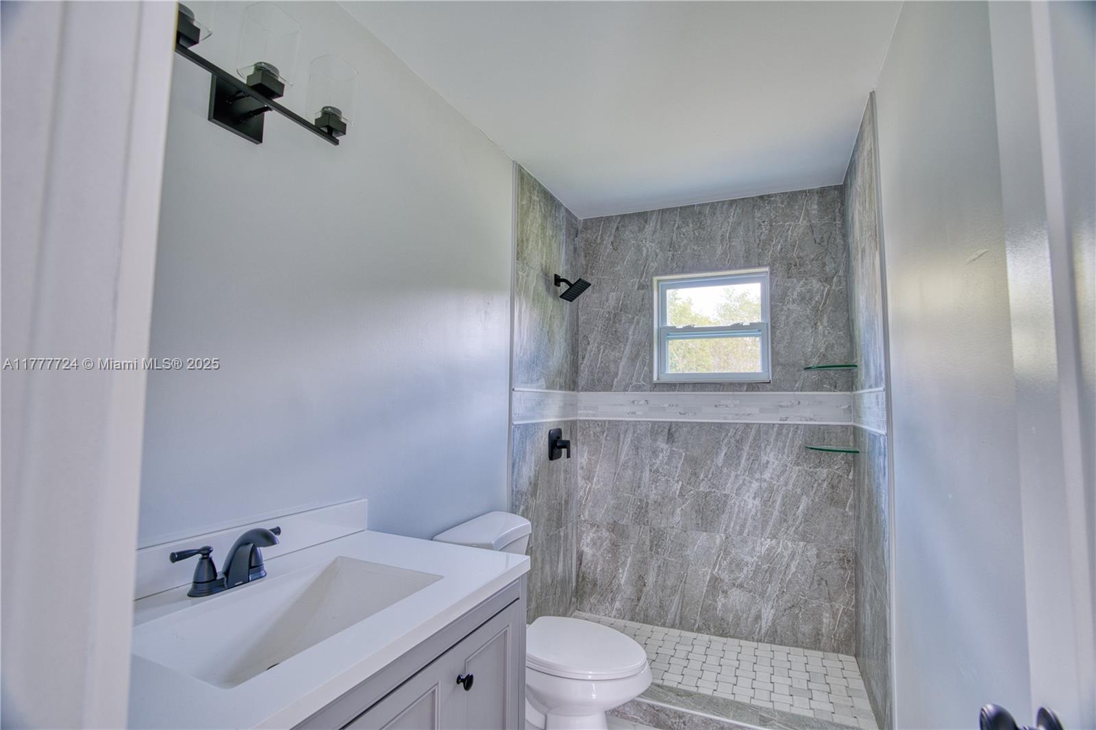 697 Pawnee Street Jupiter, FL 33458 - Photo 24 of 46 a bathroom with a sink toilet and shower