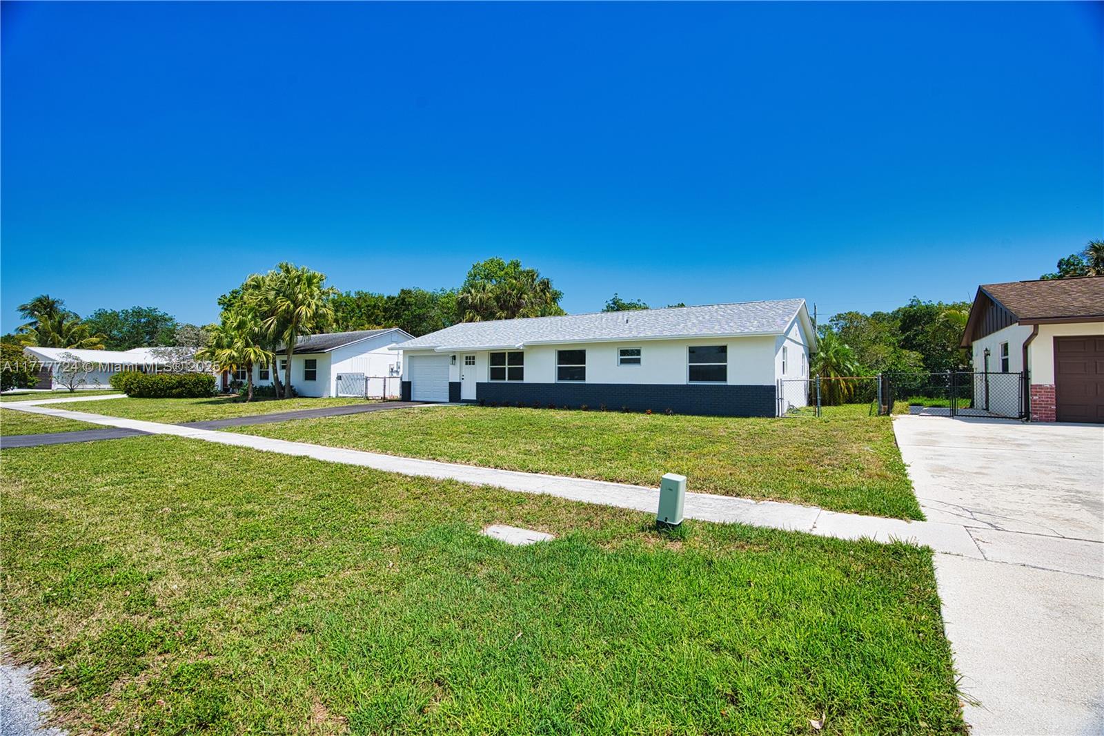 697 Pawnee Street Jupiter, FL 33458 - Photo 29 of 46 a front view of a house with a yard