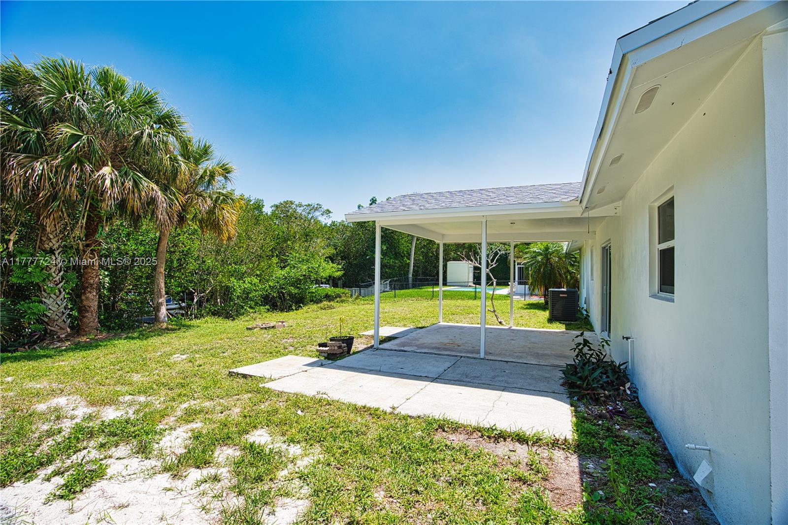 697 Pawnee Street Jupiter, FL 33458 - Photo 33 of 46 a view of swimming pool with lawn chairs and large trees