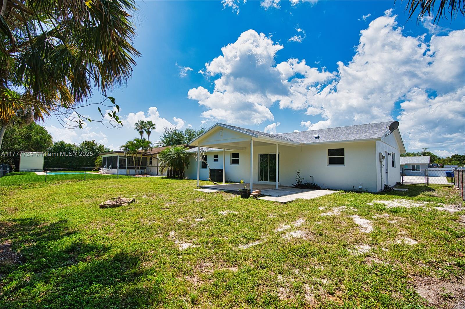 697 Pawnee Street Jupiter, FL 33458 - Photo 35 of 46 a view of a house with a big yard and a large tree