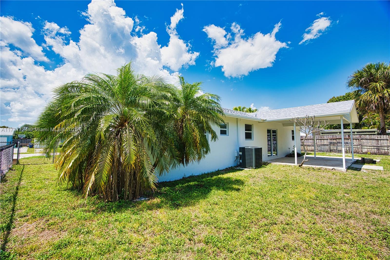 697 Pawnee Street Jupiter, FL 33458 - Photo 40 of 46 a view of a house with a swimming pool and a yard