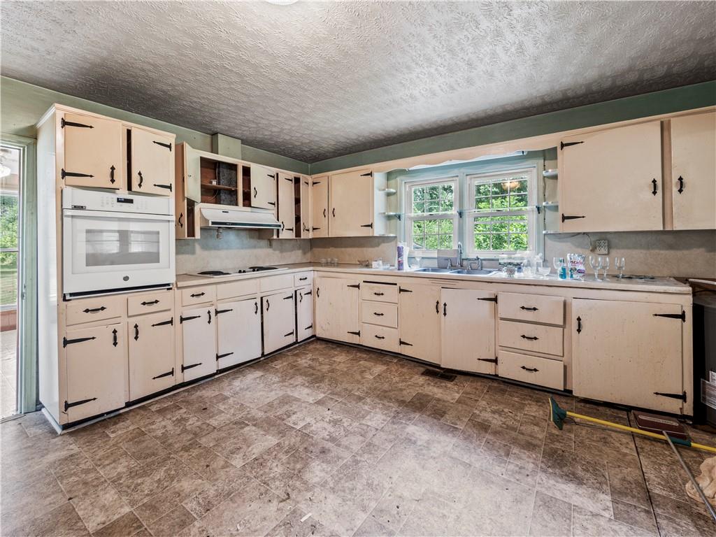 4065 Jot Em Down Road Cumming, GA 30028 - Photo 14 of 19 a large kitchen with white cabinets and a window