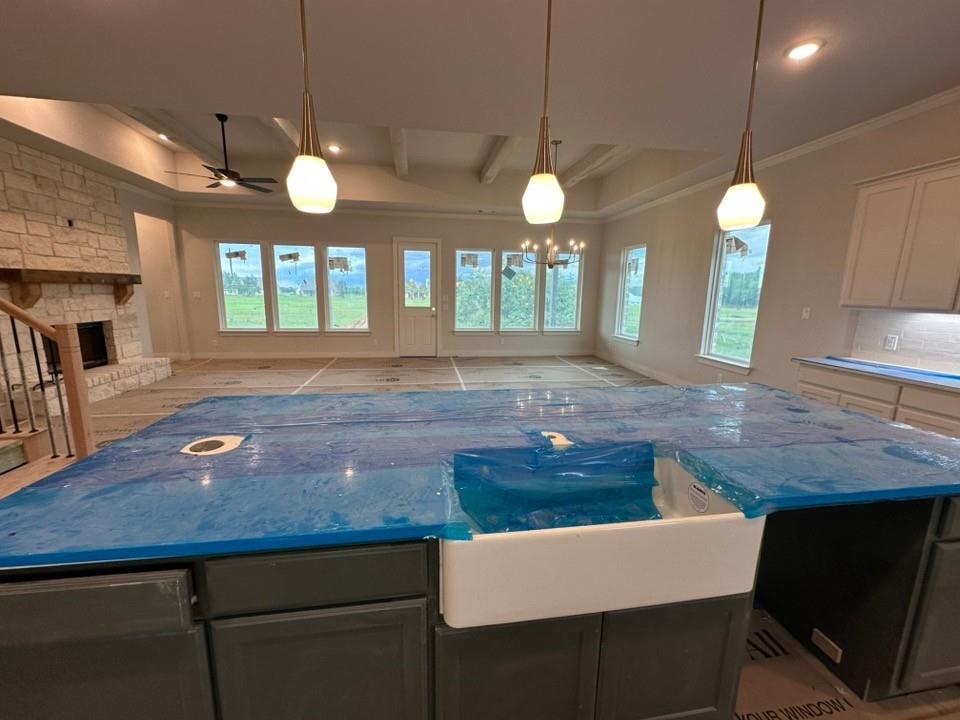 585 Brown Road Leonard, TX 75452 - Photo 12 of 29 Kitchen island featuring a farmhouse sink, dark cabinetry, and pendant lighting