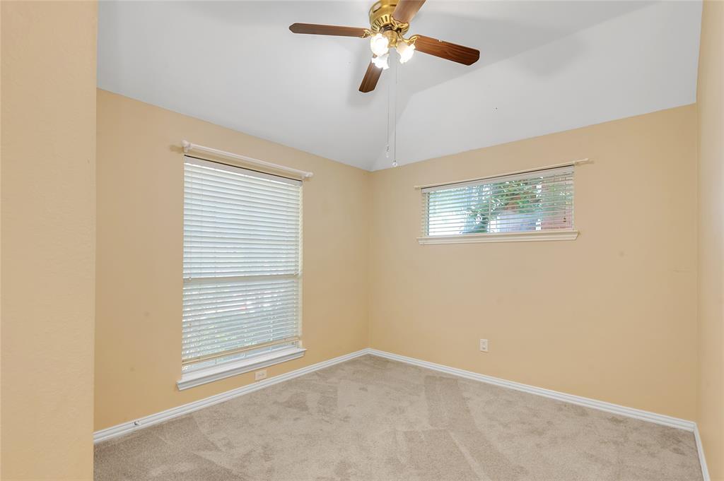 1404 Ranch Hill Drive Irving, TX 75063 - Photo 19 of 31 Room featuring a vaulted ceiling with a ceiling fan light fixture, carpet flooring, base molding, and two windows with horizontal blinds