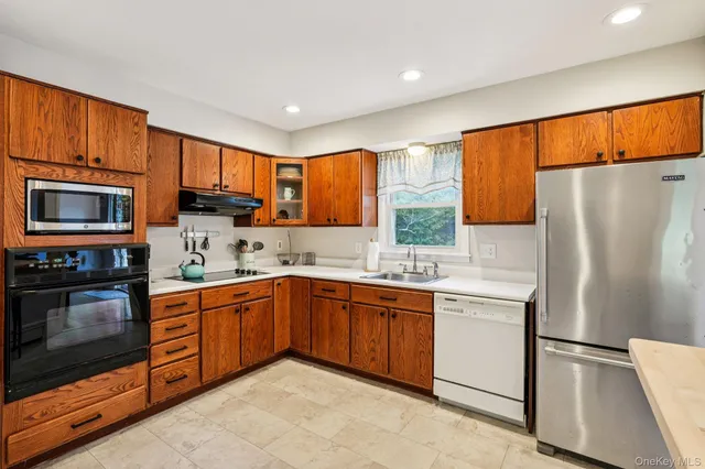 a kitchen with stainless steel appliances granite countertop a refrigerator a stove top oven a sink and dishwasher