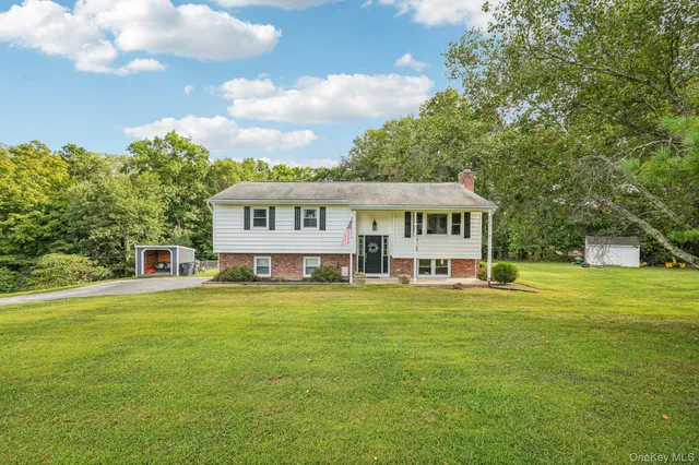 a view of a house with a big yard and large trees