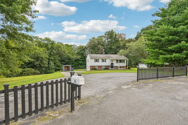 a view of a house with a yard and potted plants
