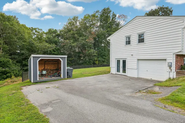 a view of backyard with small cabin and wooden fence