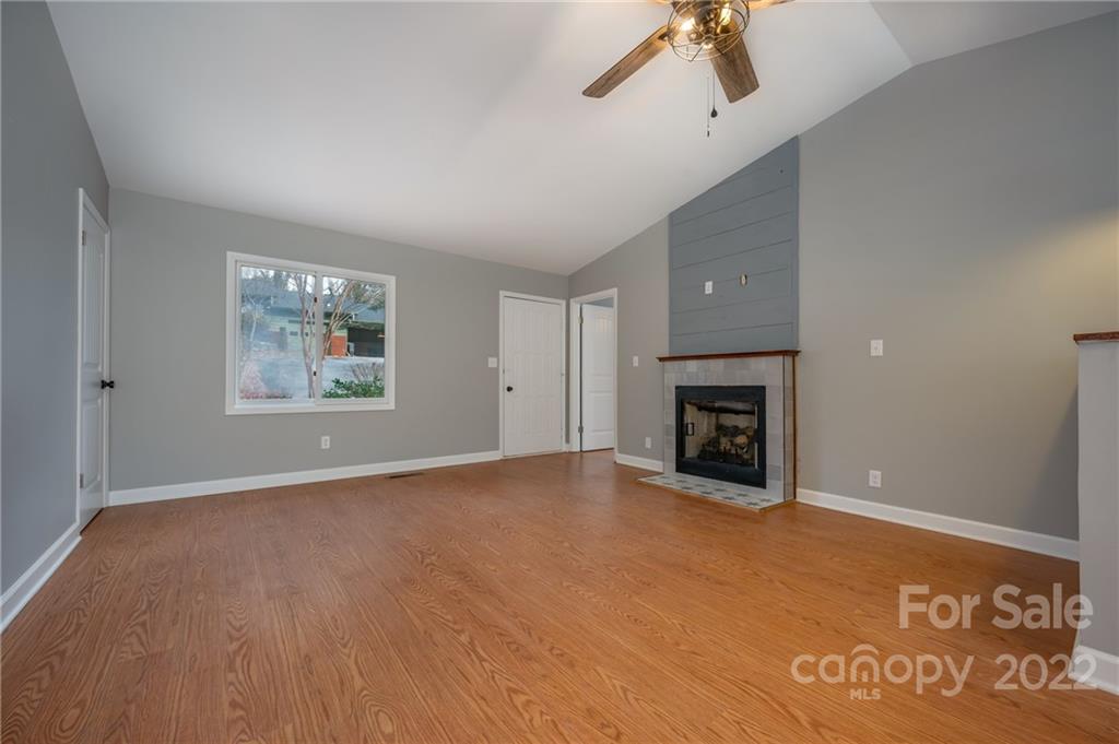 241 Hidden Hill Road Tryon, NC 28782 - Photo 7 of 39 an empty room with windows and fireplace