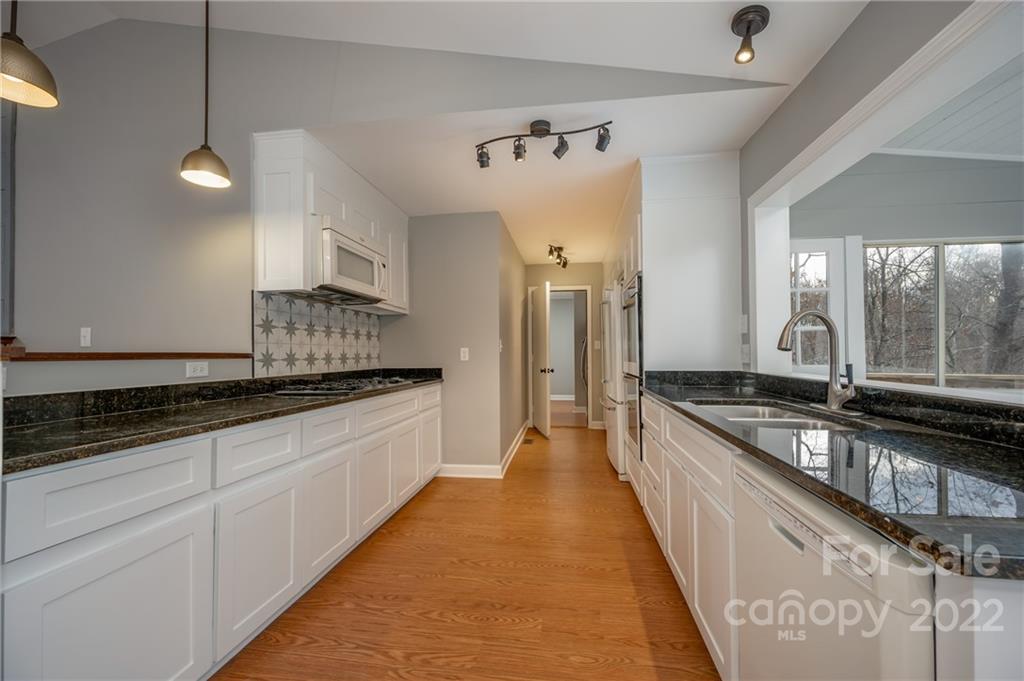 241 Hidden Hill Road Tryon, NC 28782 - Photo 10 of 39 a large kitchen with granite countertop a large counter top space a sink a stove and stainless steel appliances