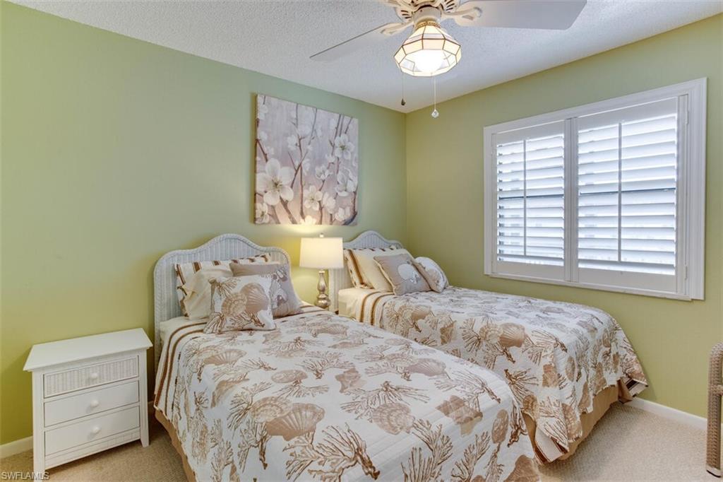 4345 27th Court Southwest, Unit 202 Naples, FL 34116 - Photo 17 of 26 a bedroom with a bed and a chandelier