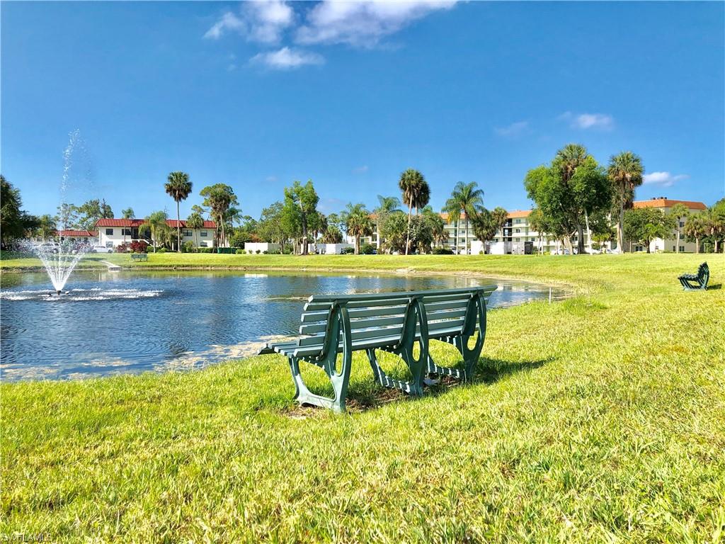 4345 27th Court Southwest, Unit 202 Naples, FL 34116 - Photo 22 of 26 a swimming pool with lawn chairs and a yard