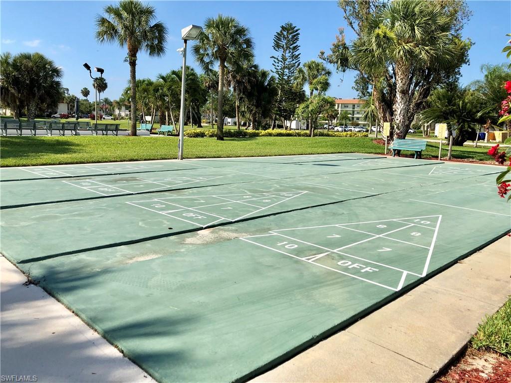 4345 27th Court Southwest, Unit 202 Naples, FL 34116 - Photo 24 of 26 a view of a tennis ground with large trees