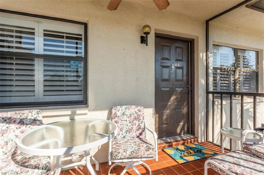 4345 27th Court Southwest, Unit 202 Naples, FL 34116 - Photo 3 of 26 a balcony with table and chairs