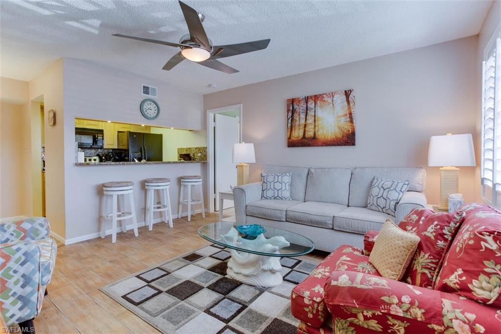 4345 27th Court Southwest, Unit 202 Naples, FL 34116 - Photo 5 of 26 a living room with furniture and a flat screen tv