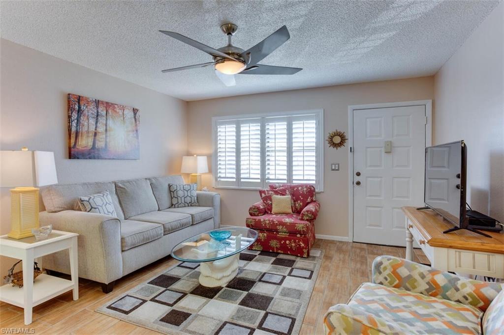 4345 27th Court Southwest, Unit 202 Naples, FL 34116 - Photo 6 of 26 a living room with furniture and a window