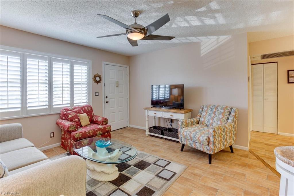 4345 27th Court Southwest, Unit 202 Naples, FL 34116 - Photo 7 of 26 a living room with furniture and a flat screen tv