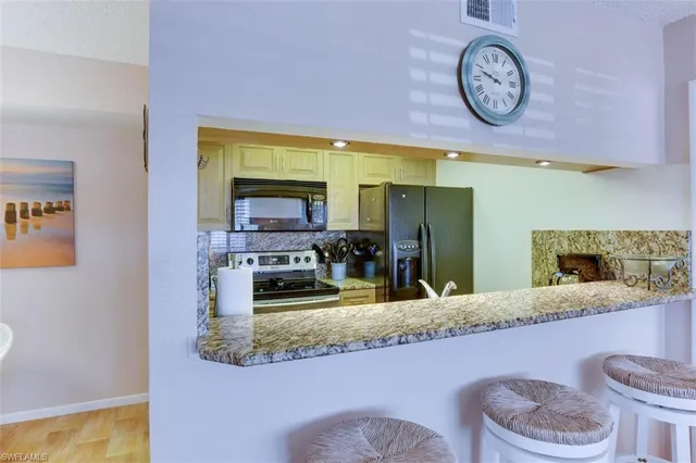 a bathroom with a granite countertop sink and a large mirror
