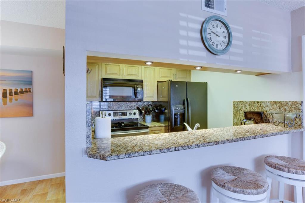 4345 27th Court Southwest, Unit 202 Naples, FL 34116 - Photo 8 of 26 a bathroom with a granite countertop sink and a large mirror