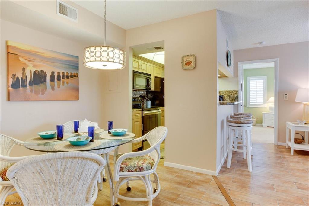 4345 27th Court Southwest, Unit 202 Naples, FL 34116 - Photo 10 of 26 a dining room with furniture and wooden floor