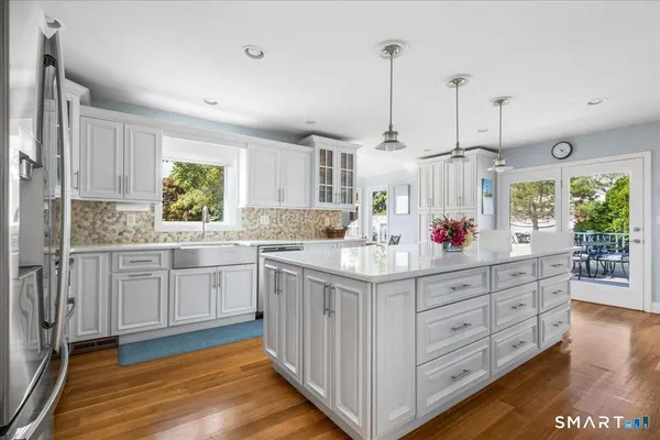 a kitchen with kitchen island granite countertop a sink window and wooden floor