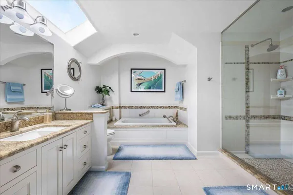 a spacious bathroom with a tub sink and mirror