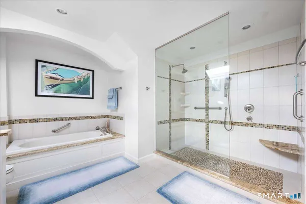 a spacious bathroom with a tub shower and mirror