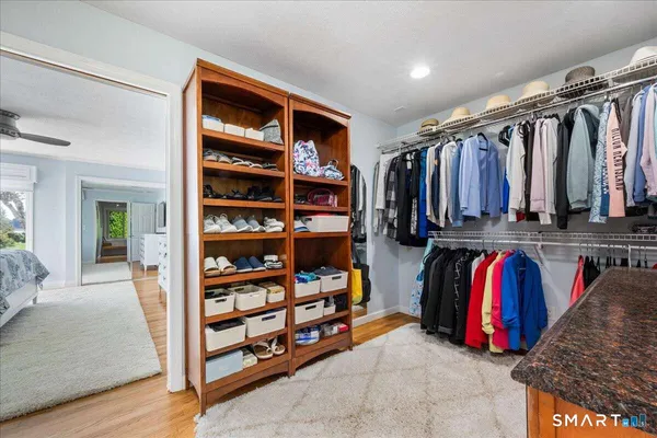 a view of walk in closet with clothes and shoes