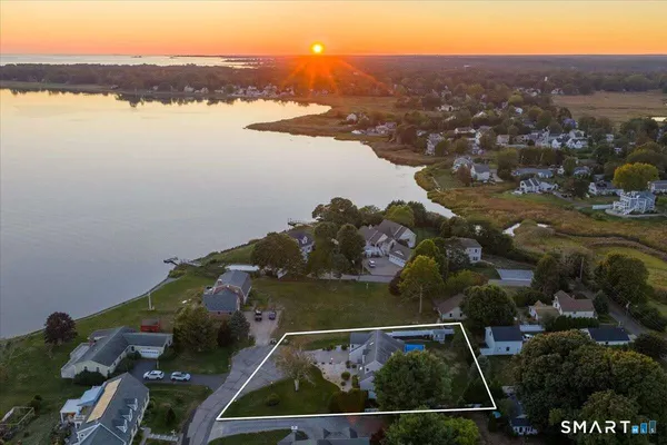 an aerial view of ocean and residential houses with outdoor space