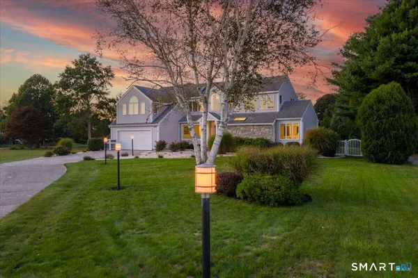 a front view of a house with a yard and trees