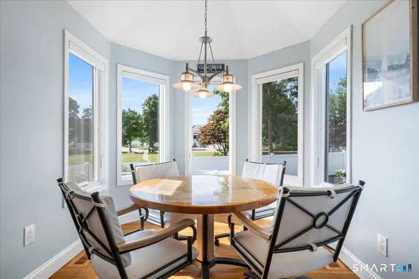 a dining room with furniture window and wooden floor