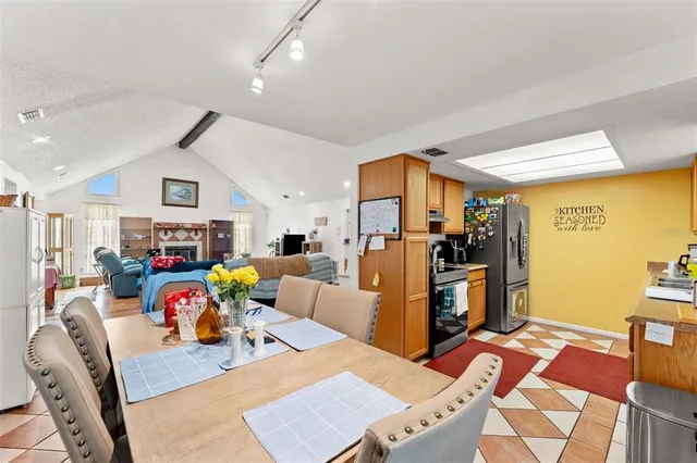 a kitchen with stainless steel appliances granite countertop a refrigerator a sink dishwasher and white cabinets with wooden floor