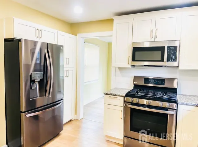 a kitchen with stainless steel appliances granite countertop a stove microwave and refrigerator