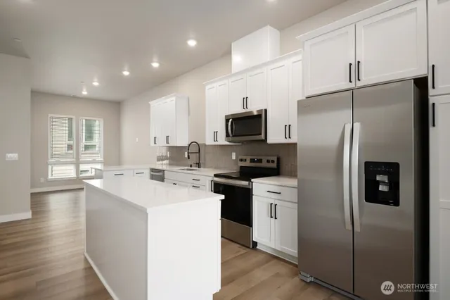 a kitchen with white cabinets and stainless steel appliances