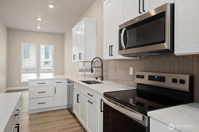 a kitchen with a sink stove and microwave