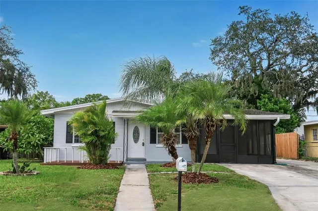 a front view of a house with a yard and tree