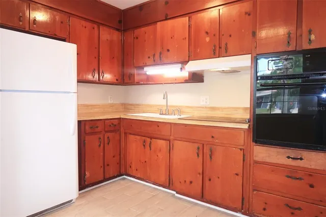 a kitchen with stainless steel appliances granite countertop a refrigerator and a stove top oven