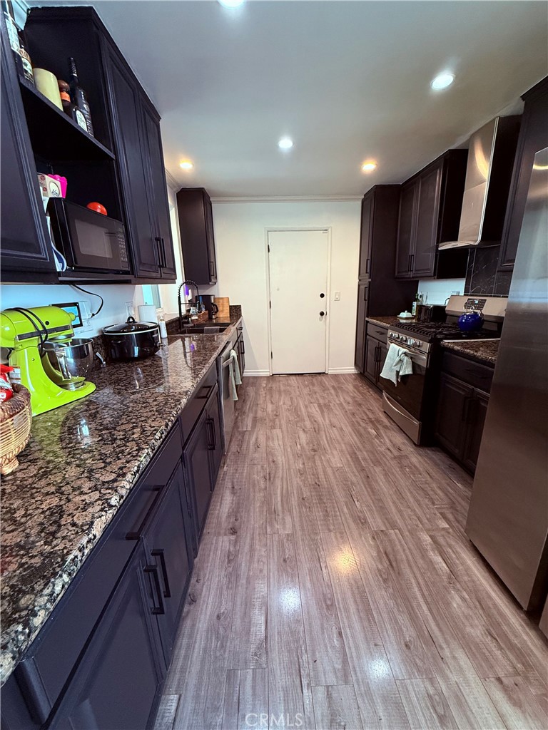19303 Kemp Avenue Carson, CA 90746 - Photo 6 of 13 a kitchen with kitchen island granite countertop a stove and a wooden floors