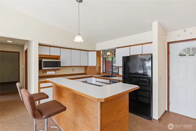a kitchen that has a table chairs stainless steel appliances and cabinets