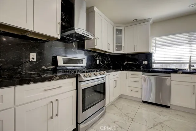 a kitchen with white cabinets and appliances